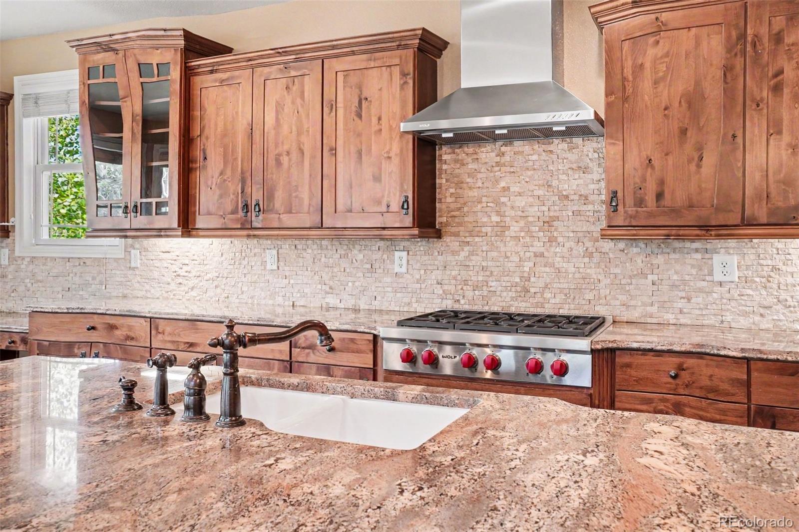 791 Elk Rest Road Evergreen, CO 80439 - Photo 12 of 46 a kitchen with granite countertop a sink a stove and a wooden cabinets