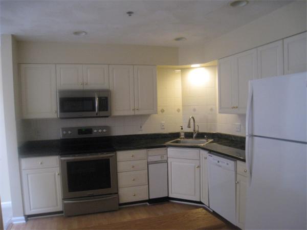 663 Lowell Street, Unit 37 Lexington, MA 02420 - Photo 2 of 13 a kitchen with granite countertop a sink stove and microwave