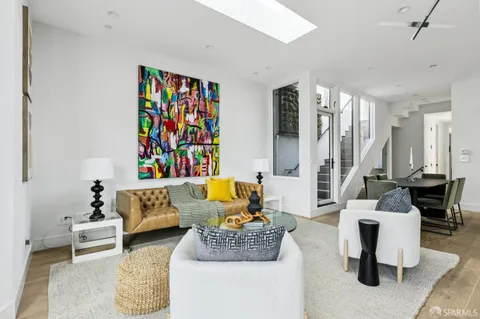 a living room with patio furniture and a painting on the wall