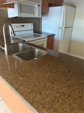 a view of a house with a bench and a grill