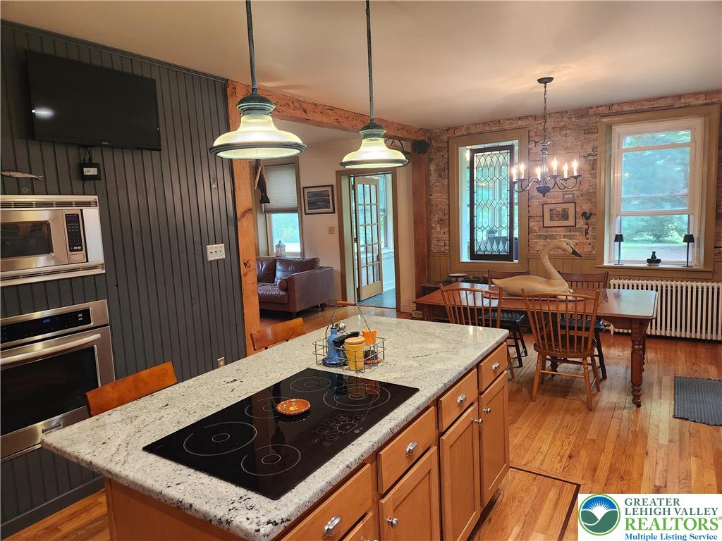 861 Municipal Road Walnutport, PA 18088 - Photo 18 of 94 a kitchen with stainless steel appliances granite countertop a stove a sink a refrigerator white cabinets and wooden floor