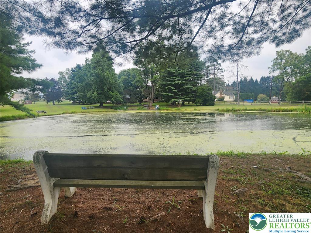 861 Municipal Road Walnutport, PA 18088 - Photo 77 of 94 a view of a lake with a bench and trees in the background