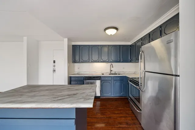 a kitchen with granite countertop a refrigerator and a sink