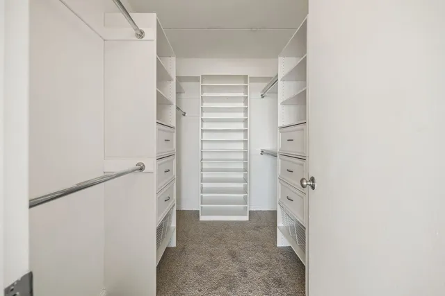 a view of walk in closet with empty racks