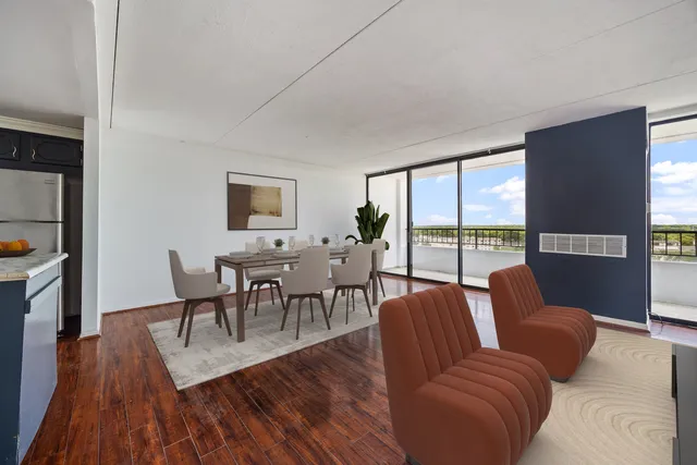 a living room with furniture wooden floor and a floor to ceiling window