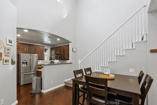 a view of a dining room with furniture a kitchen and refrigerator