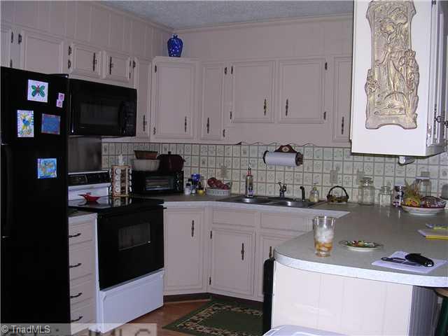 6337 Phillippi Road Julian, NC 27283 - Photo 5 of 16 Kitchen. Pickled cabinets, double sink, microwace & dishwaher remain