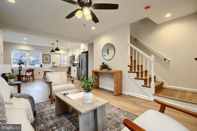a living room with furniture a flat screen tv and kitchen view