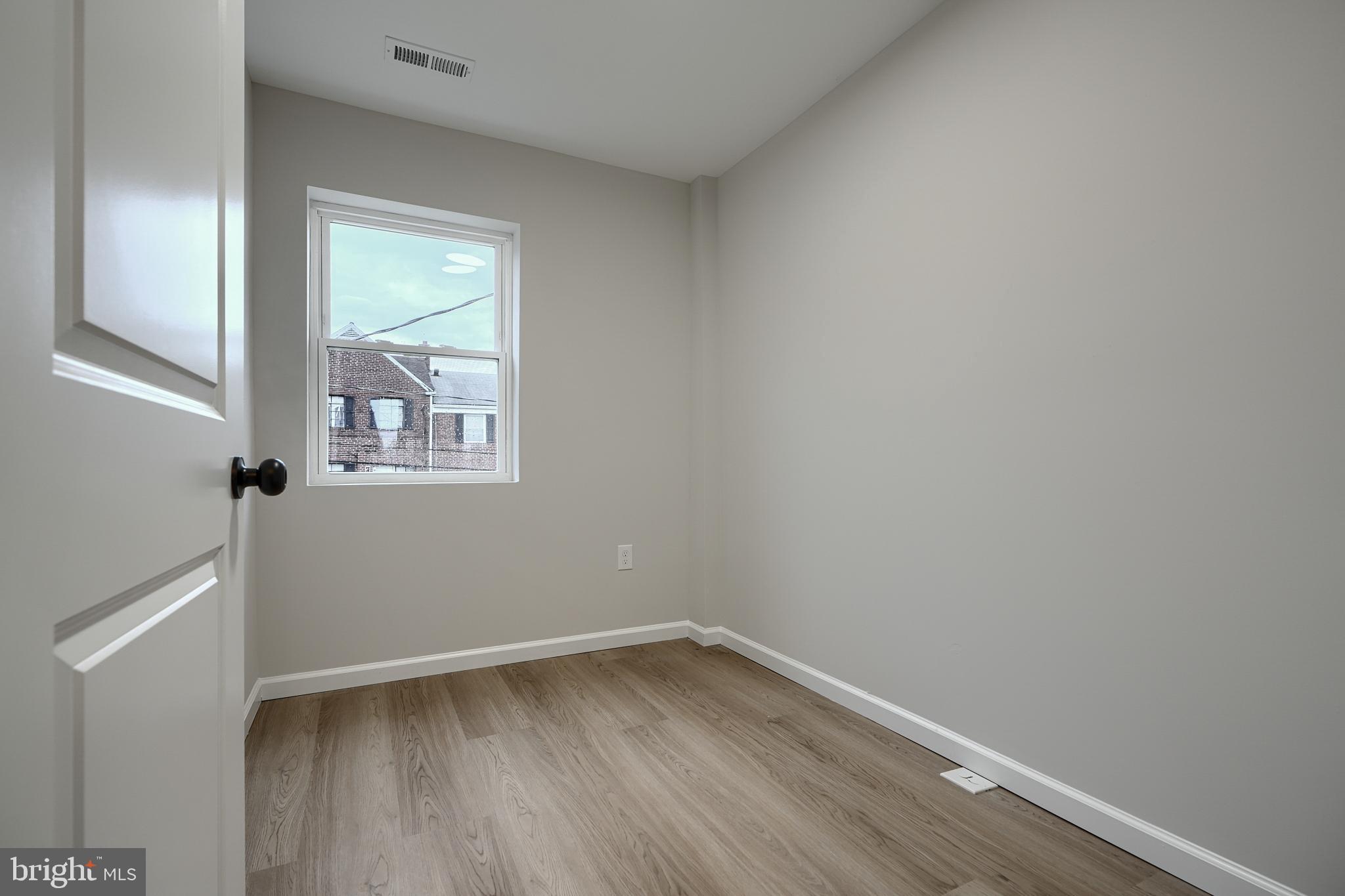 3934 Rokeby Road Baltimore, MD 21229 - Photo 18 of 38 a view of an empty room with wooden floor and a window