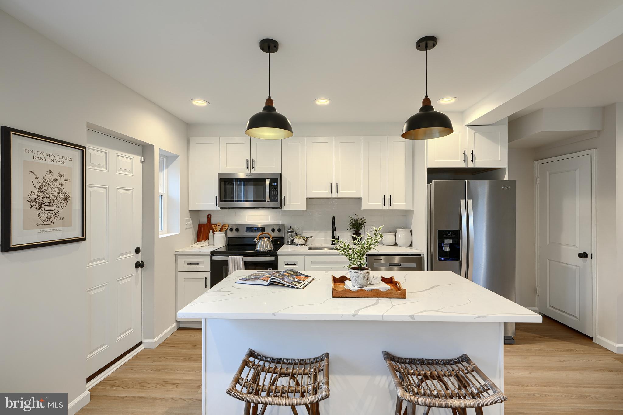 3934 Rokeby Road Baltimore, MD 21229 - Photo 10 of 38 a kitchen with stainless steel appliances kitchen island granite countertop a sink a stove and refrigerator