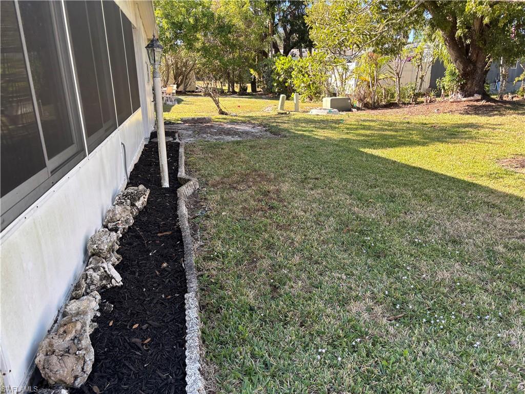 859 Manatee Road Naples, FL 34114 - Photo 33 of 37 View of green lawn featuring a sunroom