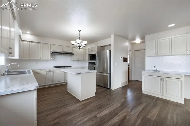 a kitchen with white cabinets and appliances