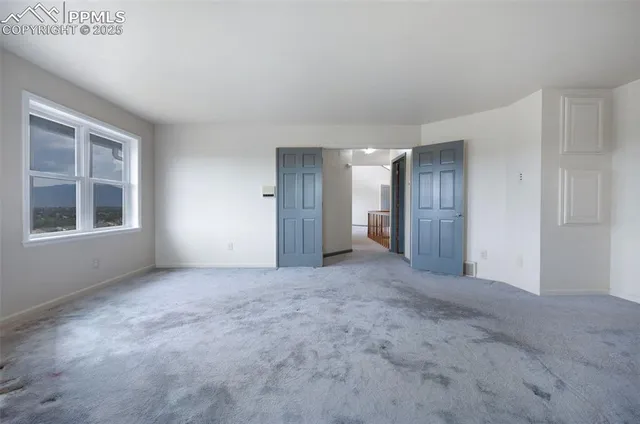 an empty room with windows and closet