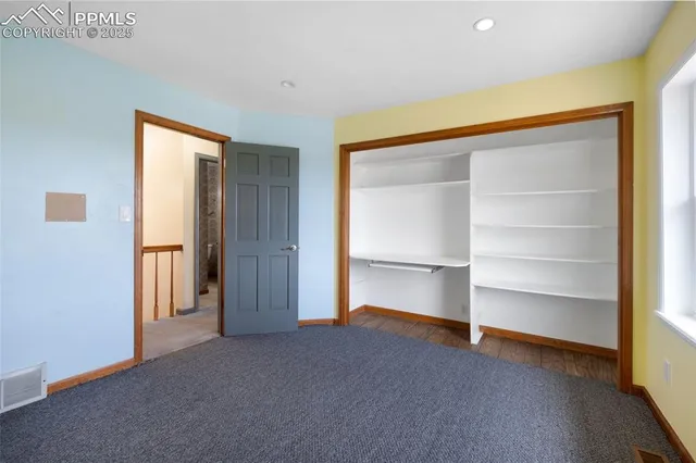 a view of an empty room with a closet and a window
