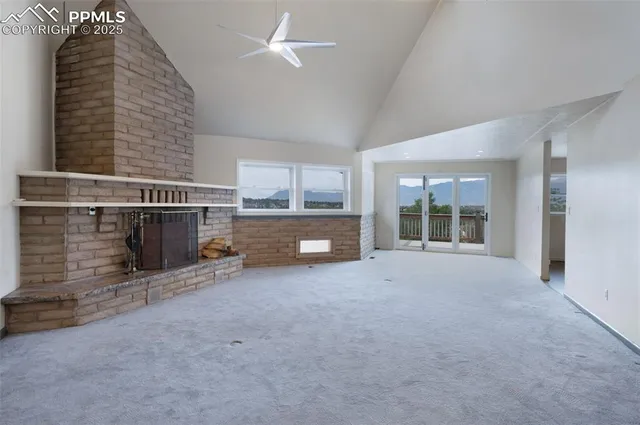 a view of an empty room with a fireplace and a large window