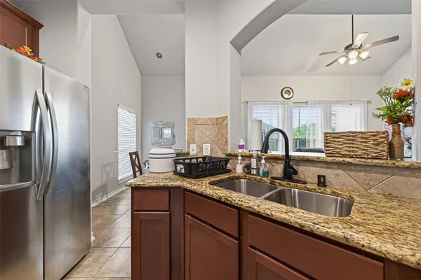 a kitchen with granite countertop a sink stainless steel appliances and cabinets