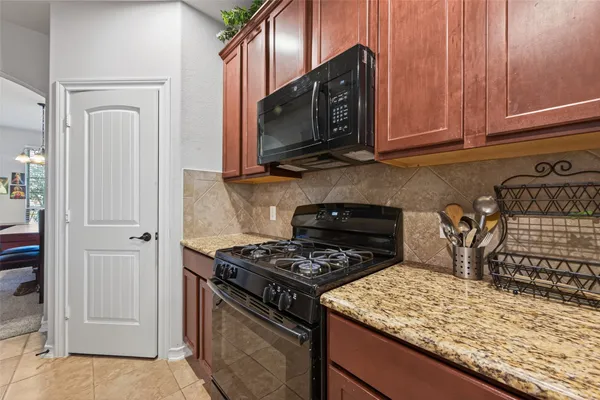 a kitchen with stainless steel appliances granite countertop a stove microwave and cabinets