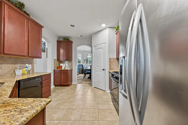 a kitchen with stainless steel appliances granite countertop a refrigerator and a sink