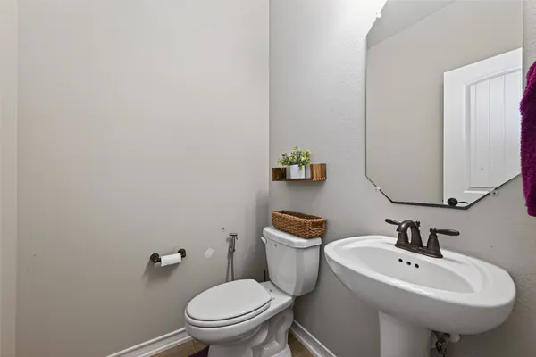 a bathroom with a sink a toilet and mirror