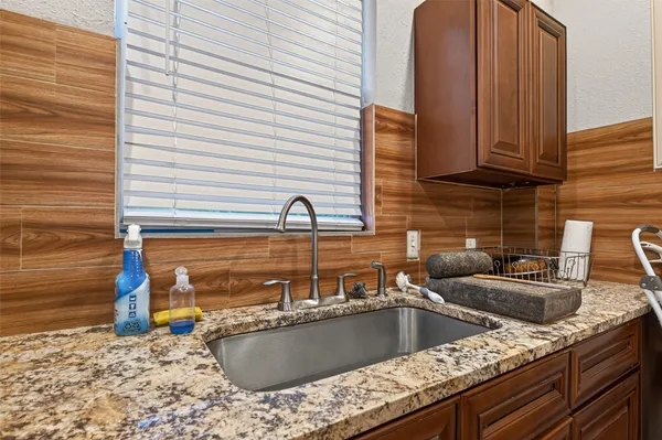 a kitchen with granite countertop a sink and a stove