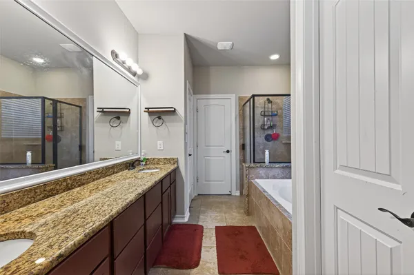 a bathroom with a granite countertop sink a mirror and shower