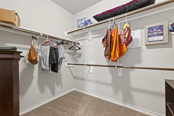 a view of walk in closet with clothes and shoes