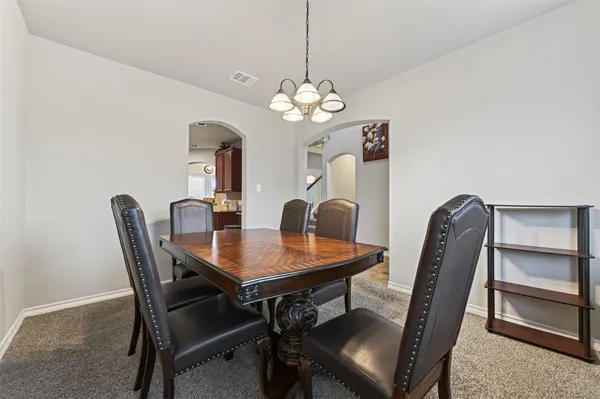 a view of a dining room with a table and chairs