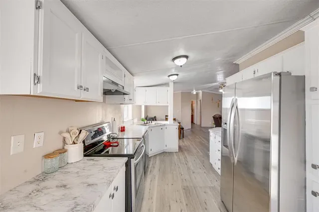 a kitchen with stainless steel appliances a refrigerator and a stove top oven