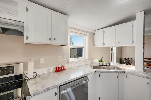 a kitchen with granite countertop white cabinets and white appliances
