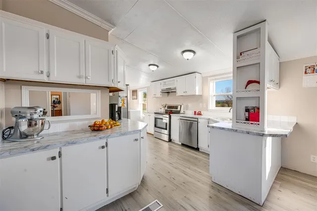a kitchen filled with white cabinets and white appliances