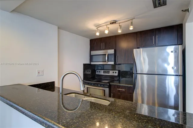 a view of a kitchen with wooden floor and a sink
