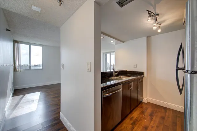 a kitchen with granite countertop a stove and a refrigerator