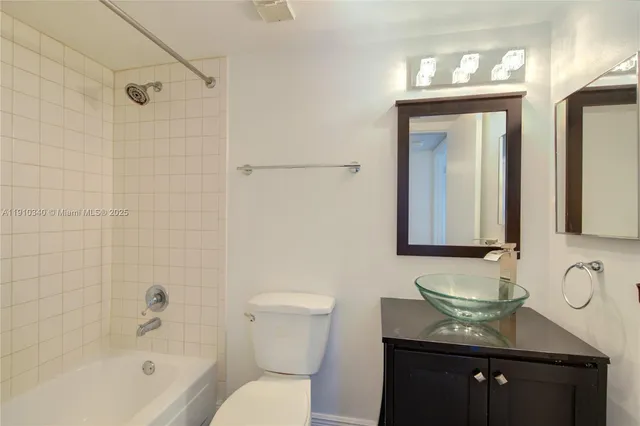 a bathroom with a granite countertop sink a toilet and bathtub