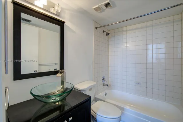 a bathroom with a granite countertop sink toilet a mirror and shower