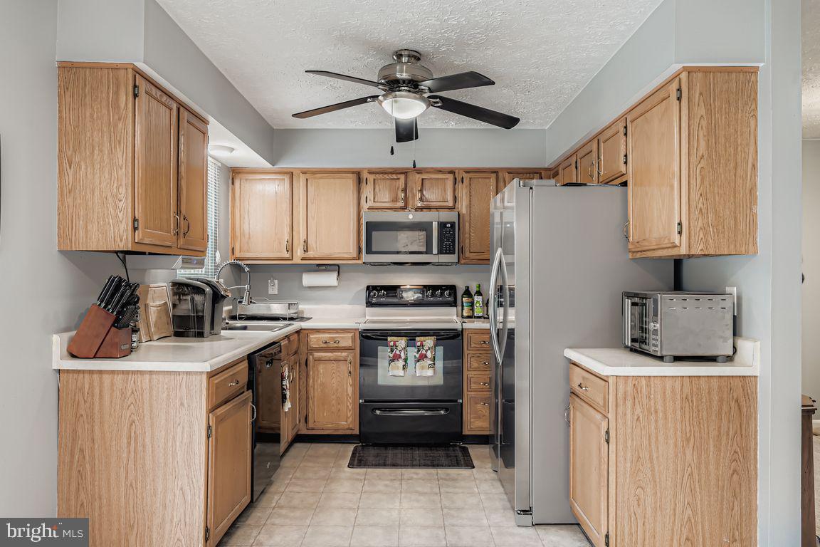 3329 Betterton Circle Abingdon, MD 21009 - Photo 12 of 38 a kitchen with stainless steel appliances granite countertop a stove top oven a refrigerator a sink and dishwasher with white cabinets