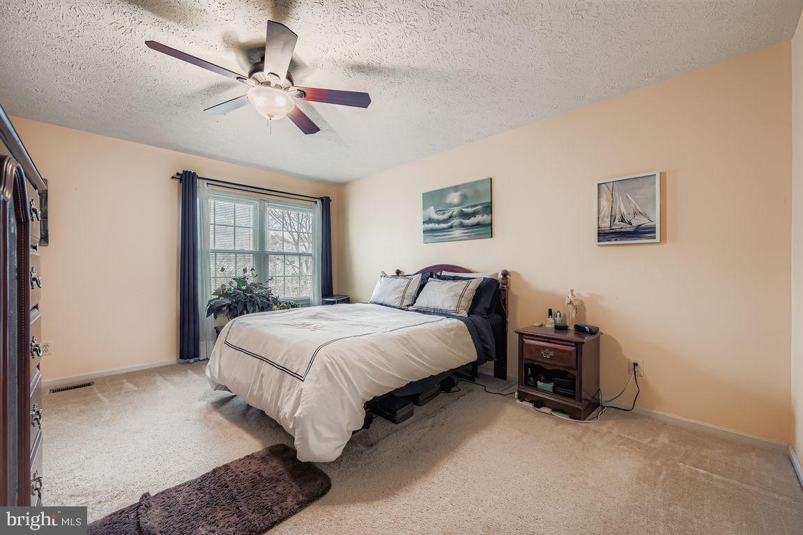 3329 Betterton Circle Abingdon, MD 21009 - Photo 16 of 38 a spacious bedroom with a bed and a chandelier