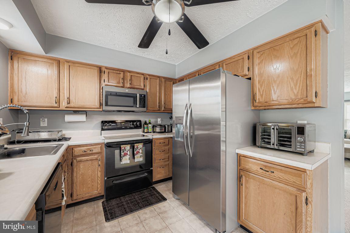 3329 Betterton Circle Abingdon, MD 21009 - Photo 9 of 38 a kitchen with stainless steel appliances granite countertop a refrigerator a stove a sink and a microwave