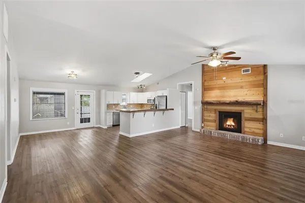 a view of a livingroom with wooden floor and a fireplace