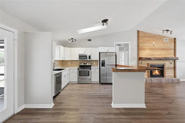 a kitchen with granite countertop a refrigerator and a stove top oven