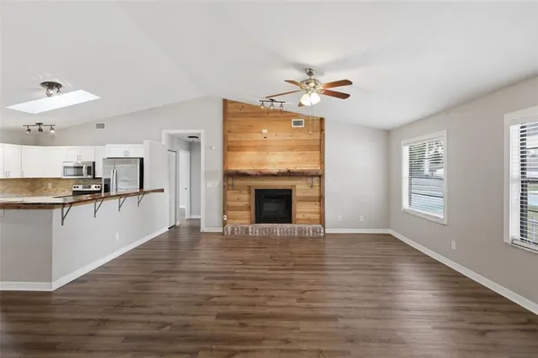 a view of a kitchen with wooden floor and a fireplace
