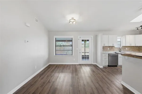 a view of a kitchen with wooden floor and a window