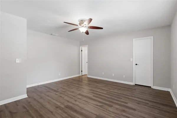 a view of an empty room with wooden floor