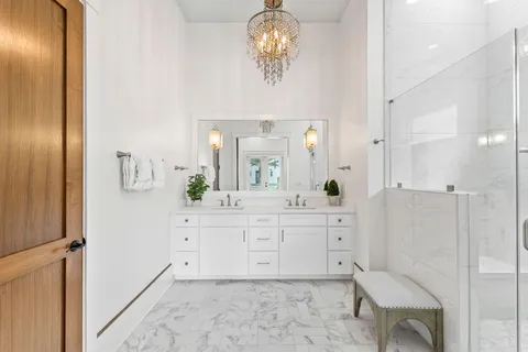 a bathroom with a sink a bathtub a light fixture and a mirror