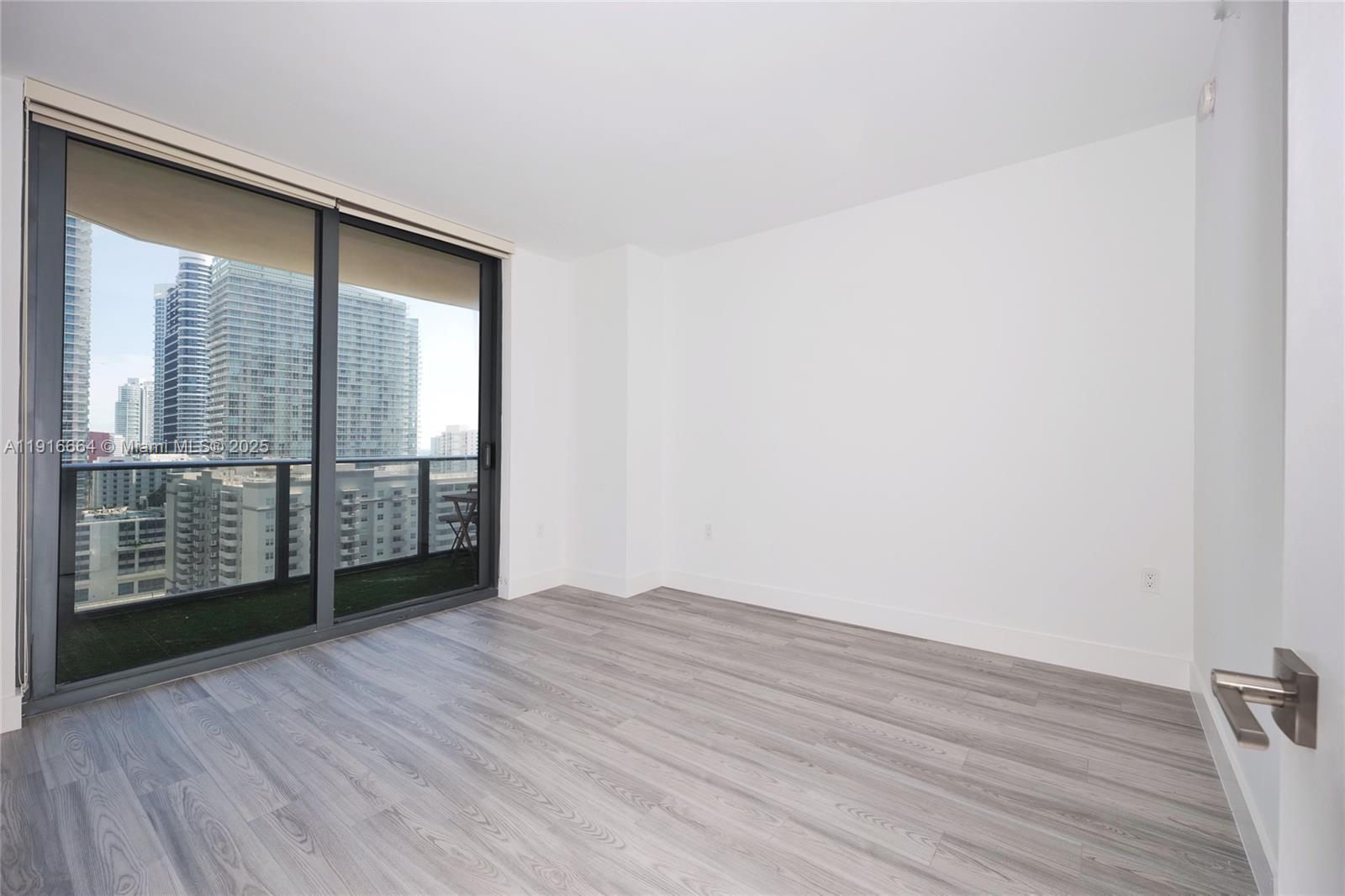 45 Southwest 9th Street, Unit 1504 Miami, FL 33130 - Photo 11 of 33 an empty room with wooden floor and windows