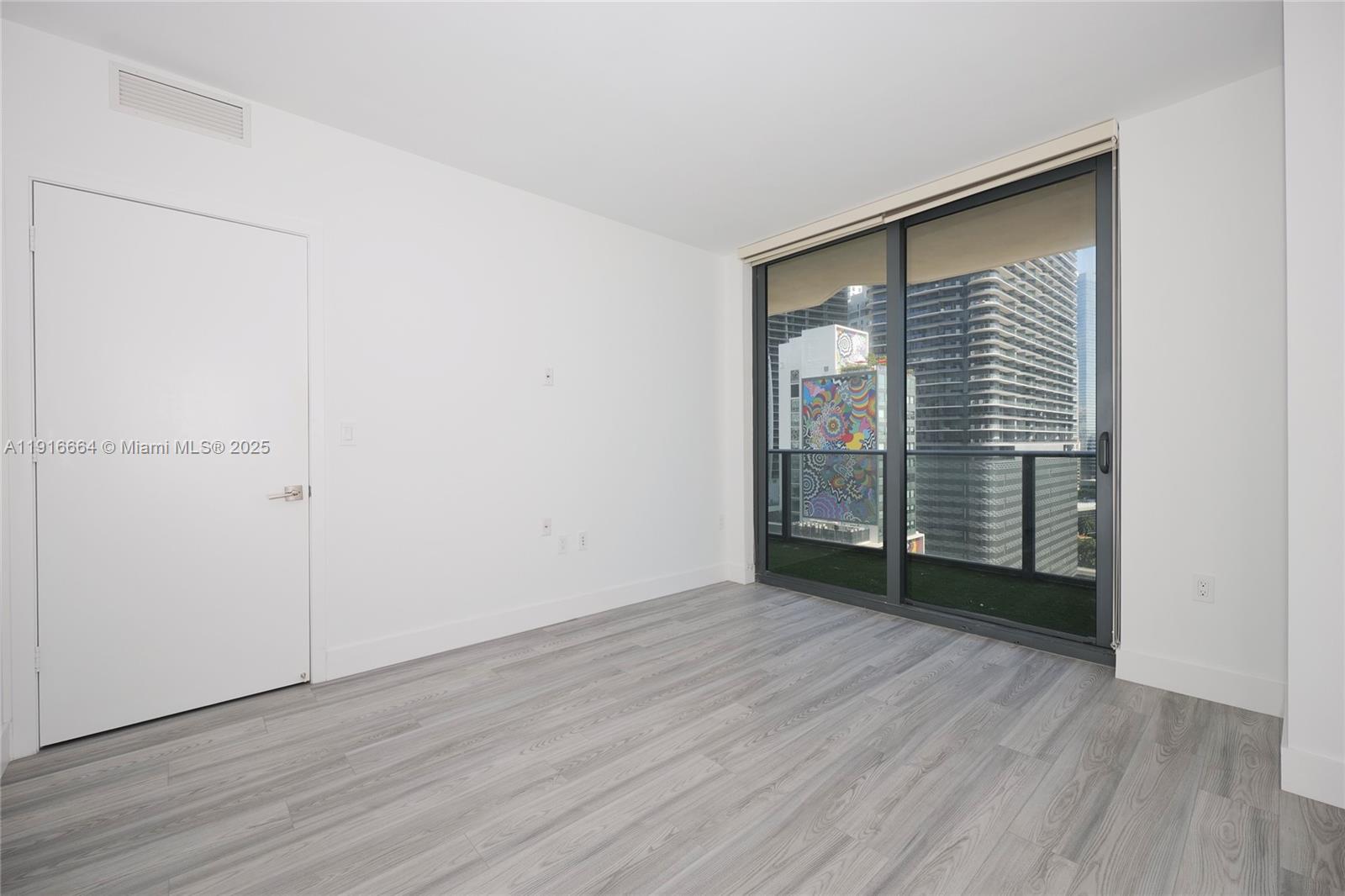45 Southwest 9th Street, Unit 1504 Miami, FL 33130 - Photo 15 of 33 an empty room with wooden floor and closet