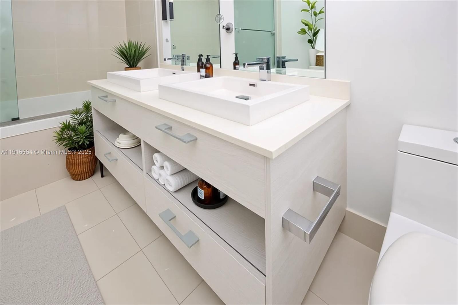 45 Southwest 9th Street, Unit 1504 Miami, FL 33130 - Photo 19 of 33 a bathroom with a sink mirror and vanity