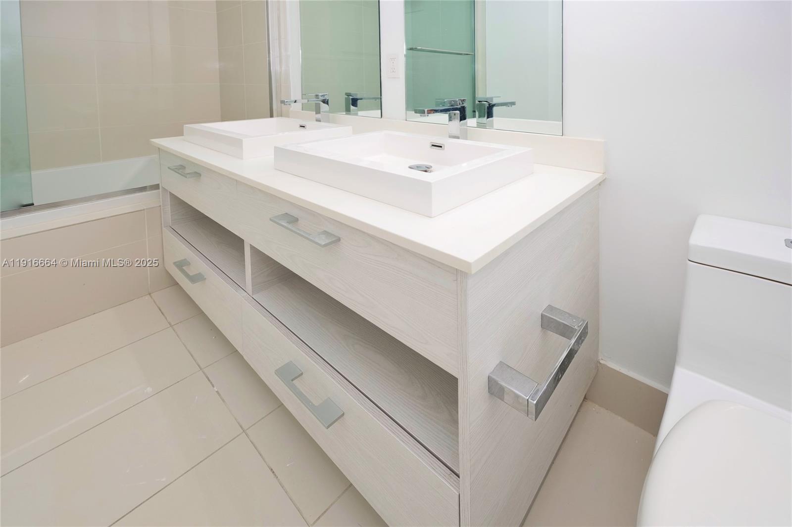 45 Southwest 9th Street, Unit 1504 Miami, FL 33130 - Photo 20 of 33 a bathroom with a sink and a mirror