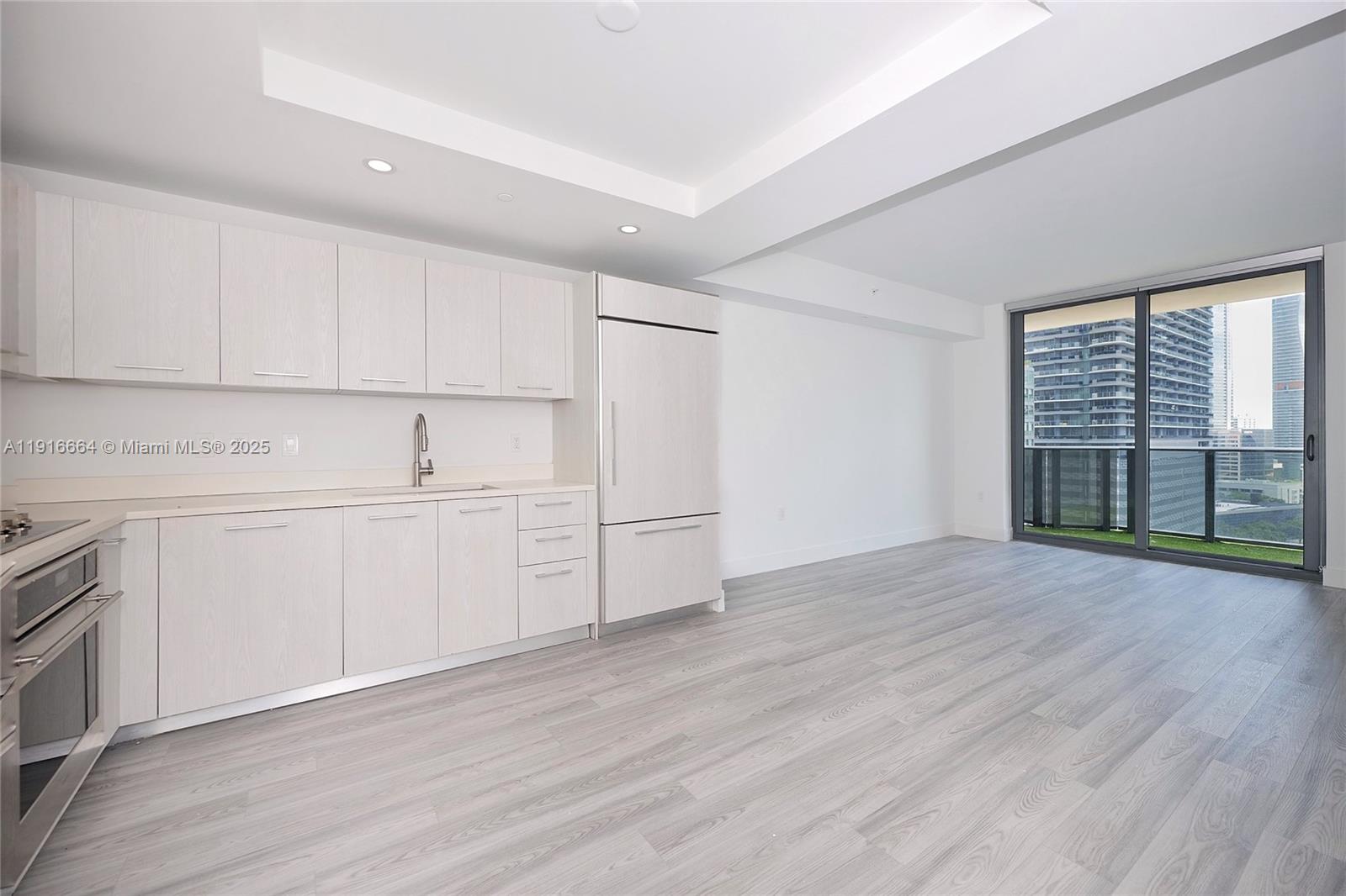 45 Southwest 9th Street, Unit 1504 Miami, FL 33130 - Photo 9 of 33 a view of a kitchen with wooden floors and white walls