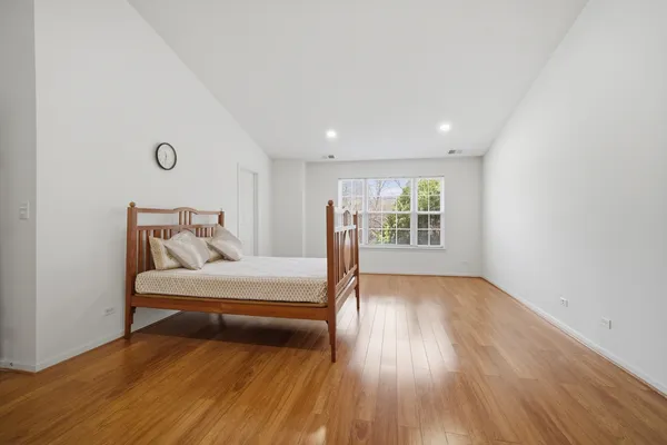 a bedroom with a bed and wooden floor