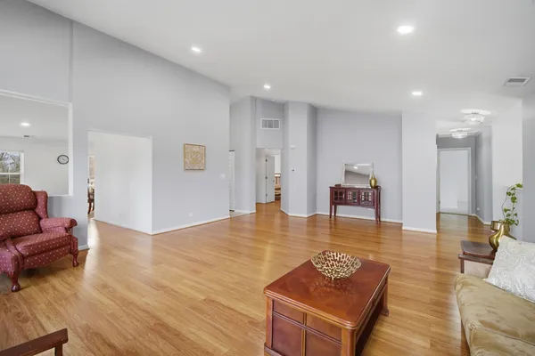 a living room with furniture and a table with wooden floor